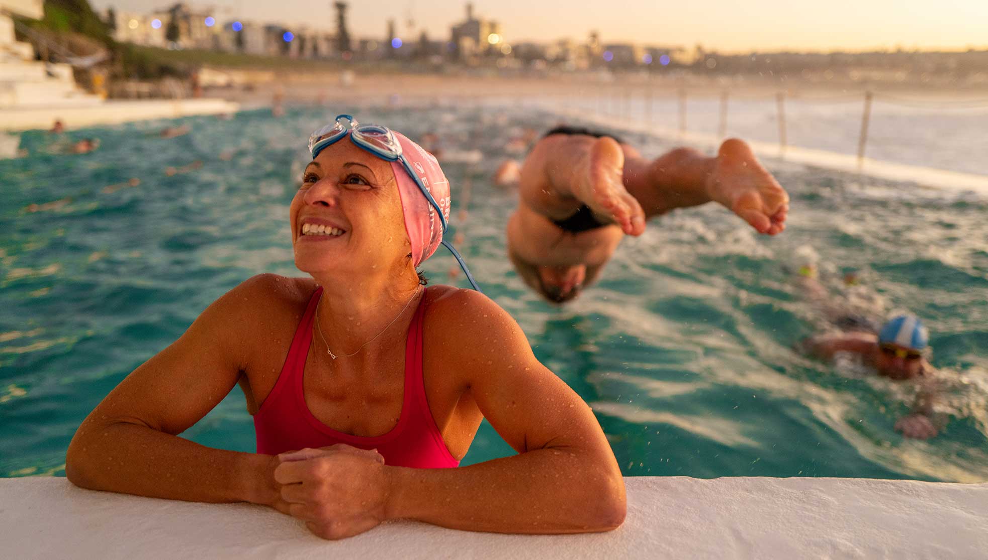 Early morning woman swimmer smiling at the edge of the pool