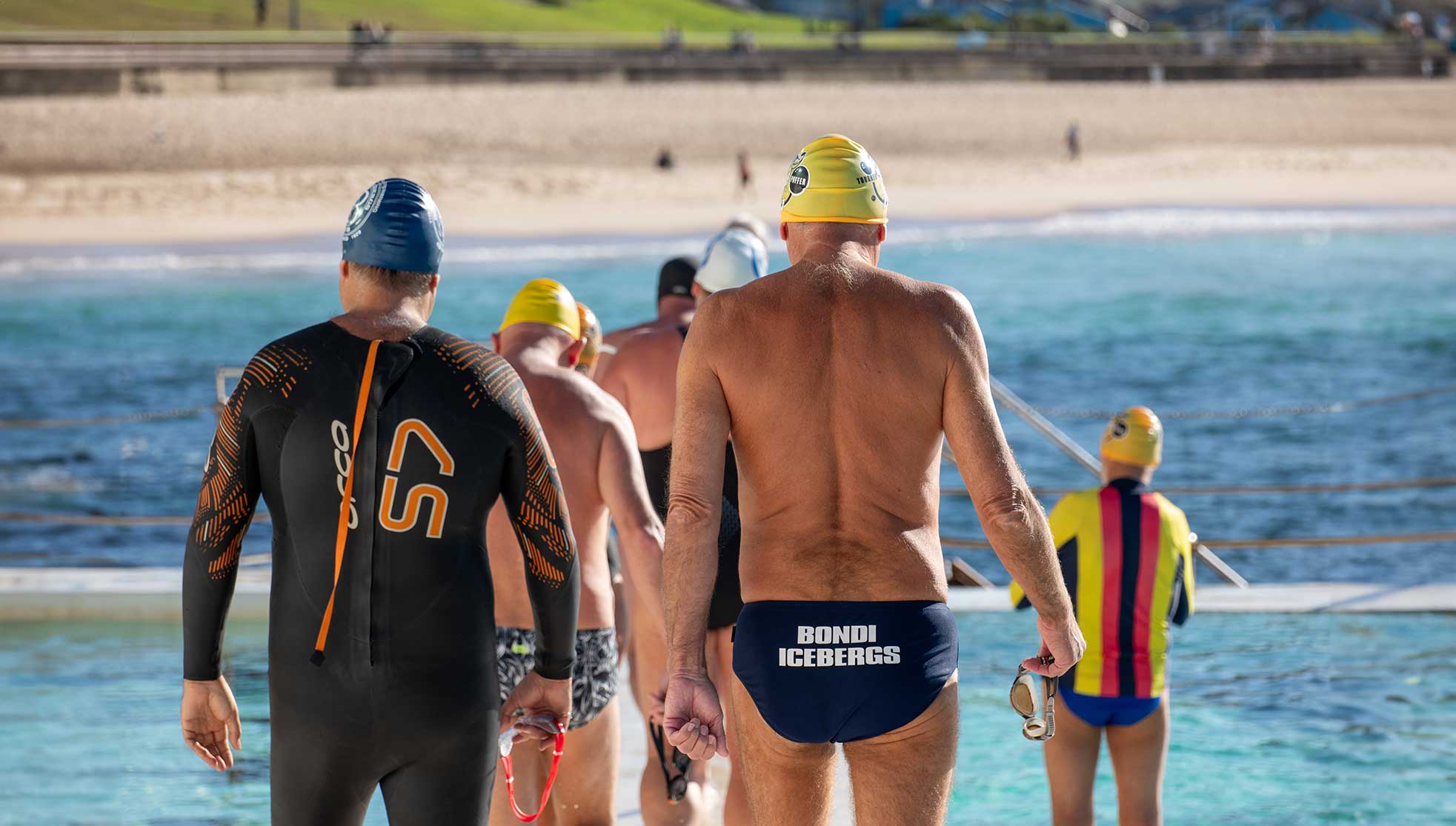 Men in swimming gear heading to the pool
